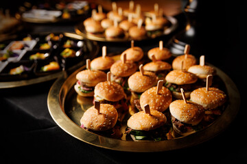 Golden tray of gourmet mini burgers ready to be served
