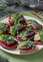 Danish sandwiches with salted herring, beetroot, pickled cucumber and mustard