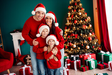 Joyful family celebration in festive decorated home near Christmas tree with smiling parents and...