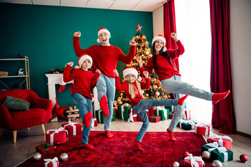 Festive family in red sweaters celebrating Christmas with a decorated tree and gifts in a cozy...