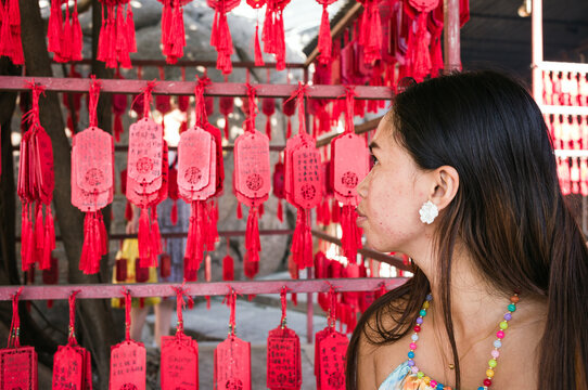 Woman looking at red prayer tags at the chinese temple, Macao