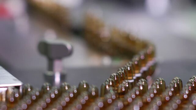 High-definition footage of an automated cleanroom assembly where glass ampoules are washed, filled with injectable medication, sterilized, and hermetically sealed. Showcases precision robotics, strict