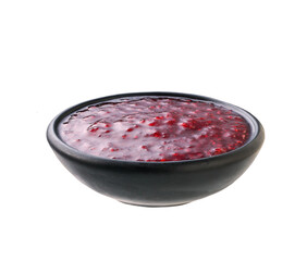 raspberry jam in a black bowl isolated on white background.