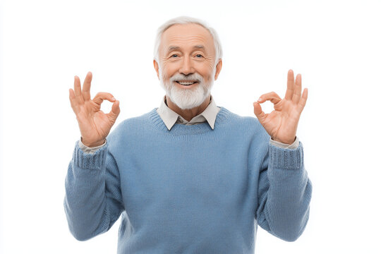 Senior man smiling warmly, standing against a clean white background making OK gesture with both hands, positive expression. Stodio shot, copy space