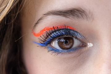 Obraz premium a human eye with the eyelid made up with blue glitter