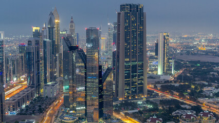 Naklejka premium Dubai International Financial Centre district with modern skyscrapers day to night timelapse