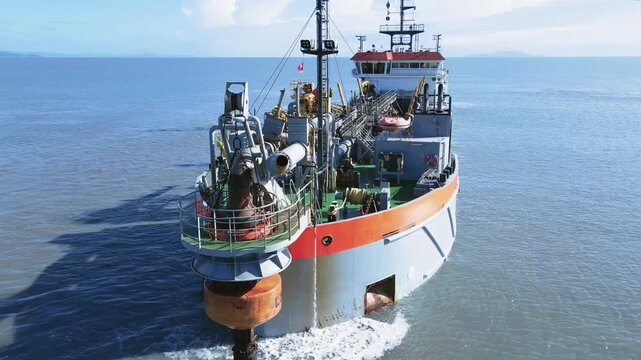 Aerial scene suction dredger ship sailing at sea, showing equipment and machinery used in large-scale dredging operations.