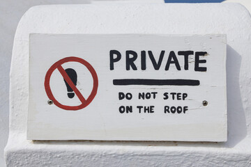 Private Do Not Step on the Roof' Warning Sign on Whitewashed Wall