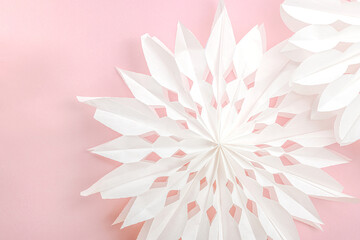 Traditional paper 3D snowflakes on pastel pink background. Winter handmade, DIY activity