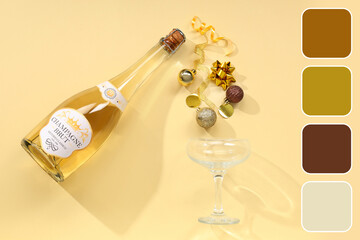 Fototapeta premium Bottle of champagne with glass and Christmas balls on yellow background