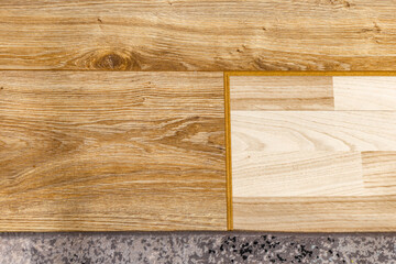 Wood laminate flooring installation on blue underlay during home renovation process