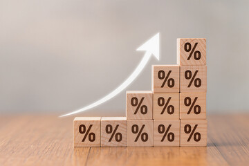Interest rate financial and mortgage rates concept. Wooden blocks with Icon percentage symbol and arrow pointing up, The economy is improving