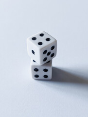 conceptual vertical photo of two white dice stacked on top of each other