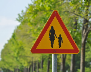 Be aware and drive slowly for children playing and walking with parents in the neighborhood, a triangular warning sign near a school zone for safety