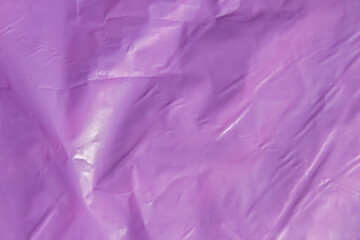 Fototapeta premium Bright purple plastic wrap sheet surface with creases and folds background
