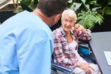 Senior patient and caregiver interacting in garden setting