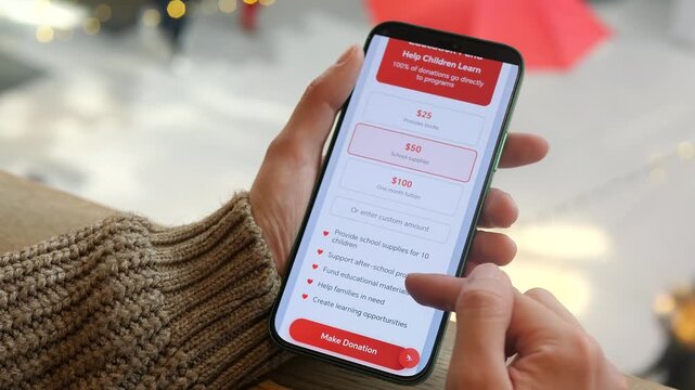 A compassionate individual makes a 10 dollars donation to a childrens charity through a dedicated service application in a shopping mall, receiving immediate gratitude confirmation. This heartwarming