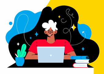 Happy Young African American Man Working on Laptop at Desk with Lamp and Plant