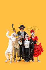 Group of children dressed for Halloween on yellow background