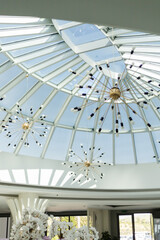 Obraz premium A spacious room showcases a beautiful glass ceiling, allowing natural light to flood in. Modern light fixtures add a touch of elegance to the atmosphere and decor