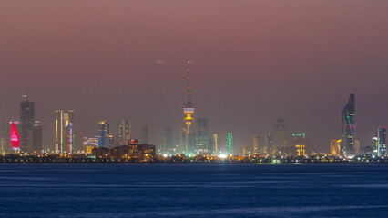 Skyline with Skyscrapers day to night timelapse in Kuwait City downtown illuminated at dusk. Kuwait City, Middle East