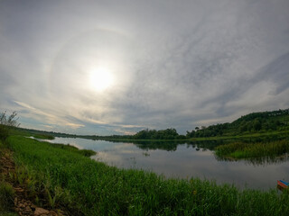 Sun Halo Over Scenic Lake and Green Landscape