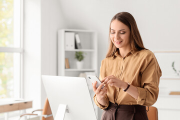 Young businesswoman using mobile phone in office