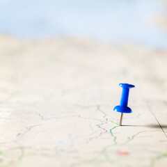 Blue thumbtack marking and showing destination location point on map background with copy space