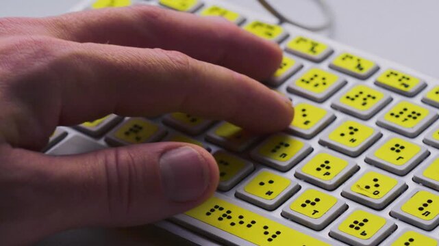 Blind person man hands using computer braille keyboard or terminal a technology assistive device for persons with disabilities. Palms moving tactile keys, creating text for visually impaired people.