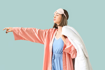 Female sleepwalker in pajamas with blanket on green background