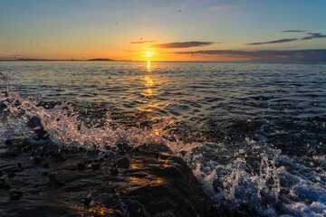 朝日の照らす磯に波が寄せて砕ける20251013