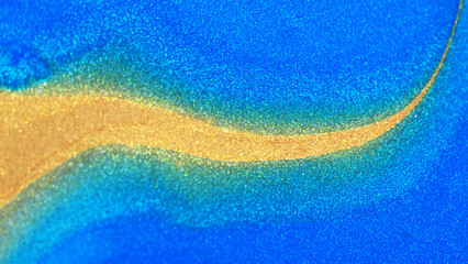 Abstract macro image of shimmering golden powder forming a wave-like curve over vivid blue surface. Modern luxury background with glitter and metallic texture.