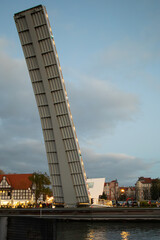 Drawbridge lifting over Motława River in Gdansk at sunset