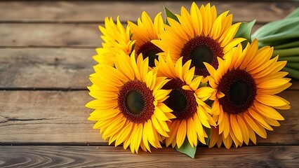Fototapeta premium A rustic wooden surface holds a sunflower bouquet glowing with warm golden backlight.