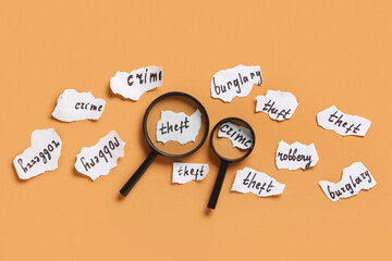 Magnifiers and paper pieces with crimes on orange background