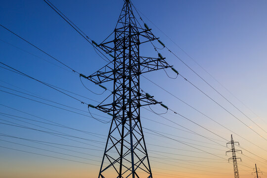 high-voltage power lines against a sunset sky on a summer day