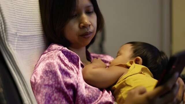 Other Rocking Her Baby While Sitting On Office Chair, A mother sways her baby on an office chair, tender smiles amid paperwork, ideal for heartfelt family video or multitasking parenthood. - Powered by Adobe
