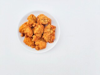 Breaded fried chicken in a white plate on a white background.