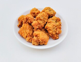 Breaded fried chicken in a white plate on a white background.