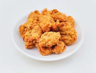Breaded fried chicken in a white plate on a white background.