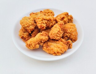 Breaded fried chicken in a white plate on a white background.