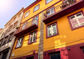 Fototapeta premium Colorful window on an old European house facade, surrounded by bright stone walls and traditional