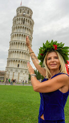 Female student proudly posing with laurel crown beneath Pisa’s iconic Leaning Tower after...