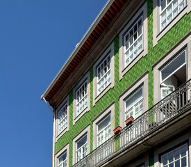 Obraz premium Old Portuguese building with stone walls, windows and balconies, showcasing traditional European