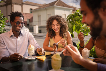 Diverse group of happy friends eating traditional italian granita at an outdoor cafe in summer. Concept of authentic multi-ethnic friendship, travel lifestyle in Sicily, enjoying a Sicilian breakfast.