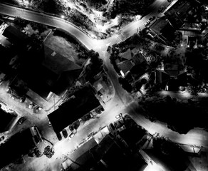 Drone shot of Tropea at night with glowing buildings and dark sea in summer season