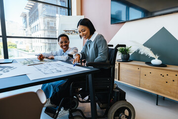 Two women working together on architectural plans in a modern office