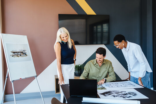 Colleagues discussing architectural plans in a modern workspace