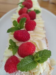 Close-up of Raspberry Roulade with Whipped Cream and Fresh Mint