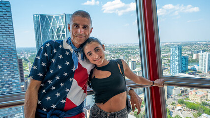 Girl and her father suspended on a glass in a Calgary rooftop